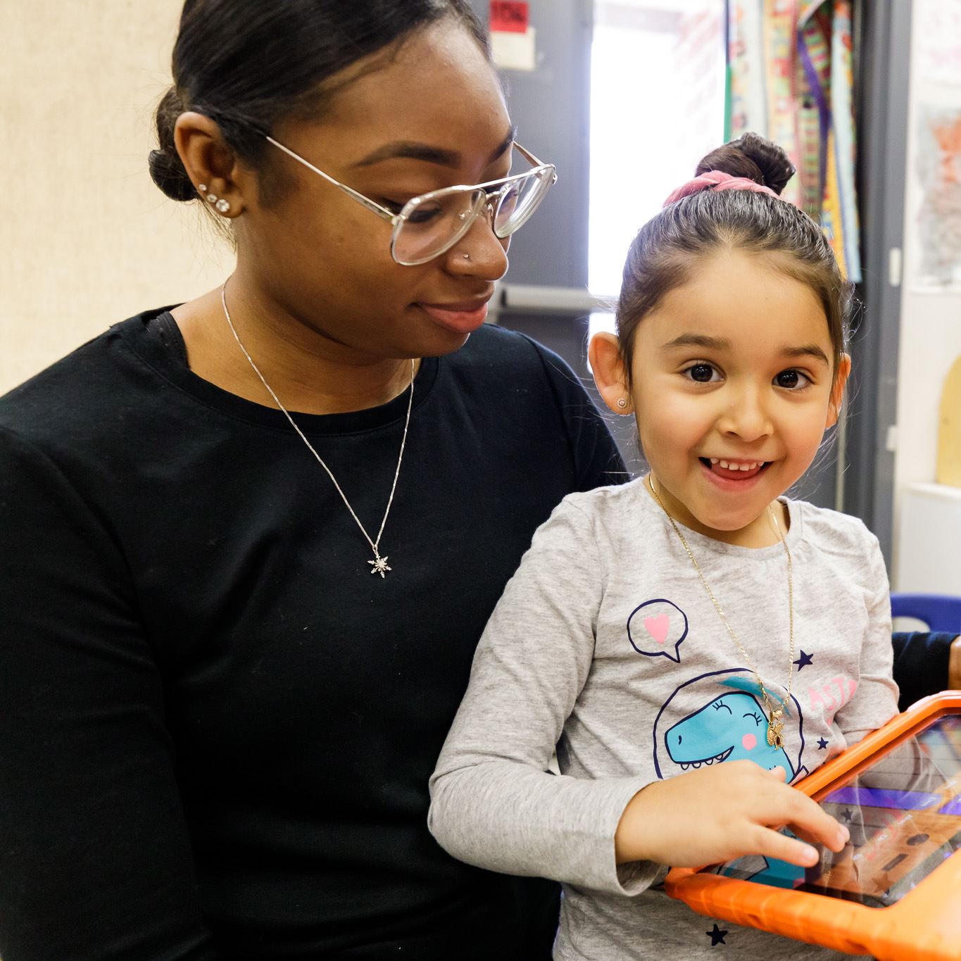  photo of a teacher and student on an iPad